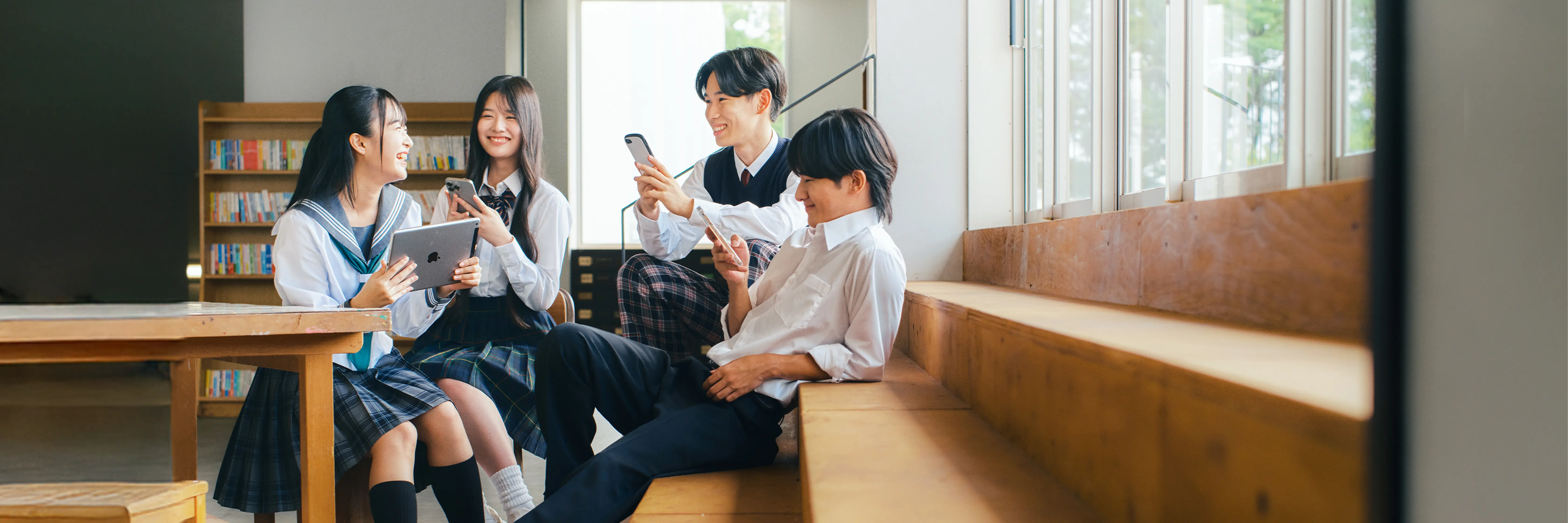 高校生が端末を使いながら進路を話し合う様子